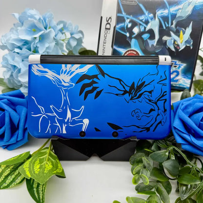 Zeigt den Nintendo 3DS XL Blau Pokemon Design mit Weißer Grundfarbe.